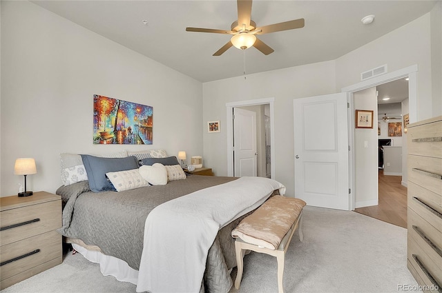 bedroom featuring visible vents, light colored carpet, and a ceiling fan