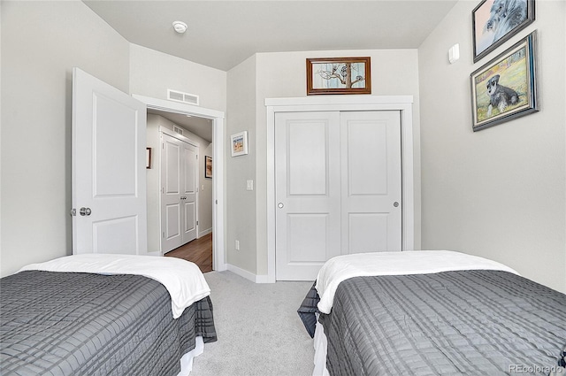 bedroom featuring visible vents, light carpet, baseboards, and a closet