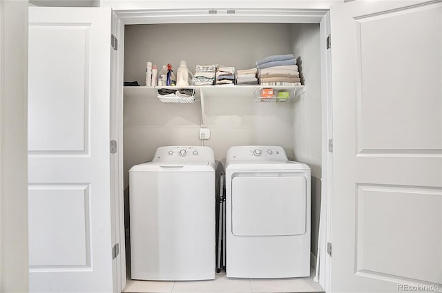 laundry room featuring light tile patterned floors, laundry area, and washer and clothes dryer