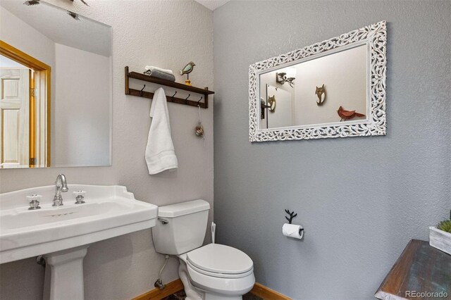4230 S Meadow Brook Ln, Evergreen, CO 80439 - half bath featuring toilet, baseboards, and a sink