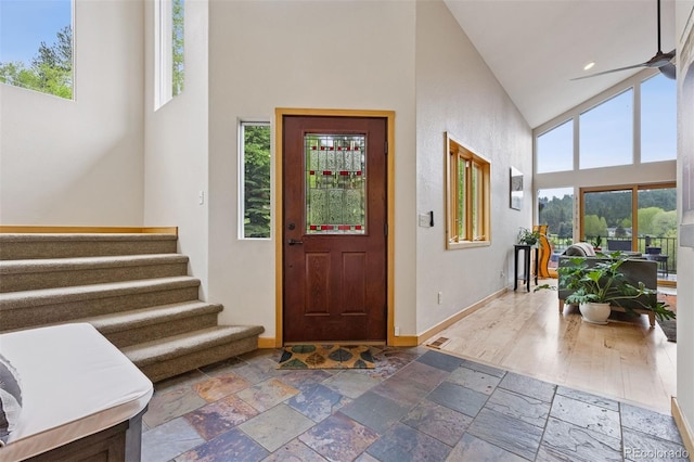 4230 S Meadow Brook Ln, Evergreen, CO 80439 - entrance foyer featuring high vaulted ceiling, baseboards, healthy amount of natural light, and stone tile floors