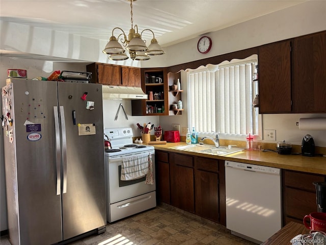 kitchen with white appliances, stone finish floor, light countertops, under cabinet range hood, and a sink