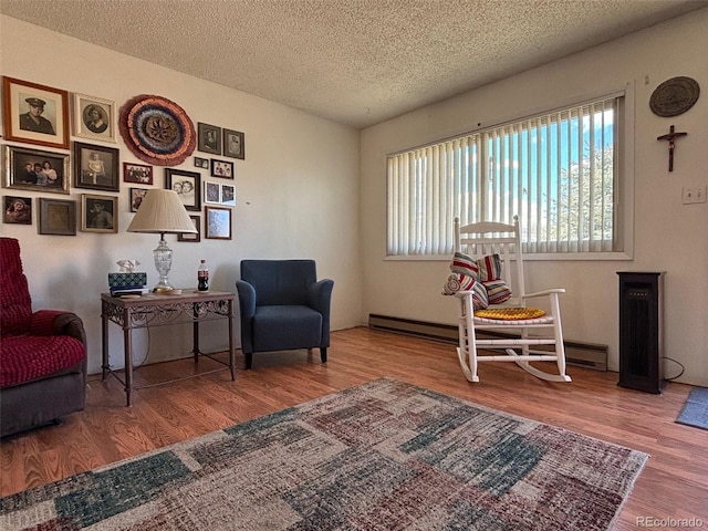 sitting room with a textured ceiling and wood finished floors