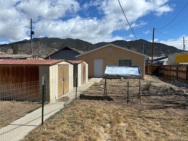 view of property exterior with an outbuilding, a mountain view, and stucco siding