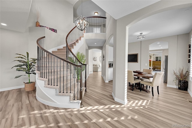 entrance foyer with a notable chandelier, a high ceiling, and light wood-type flooring