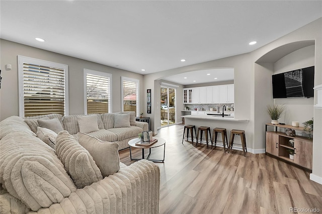 living room with sink and light hardwood / wood-style floors