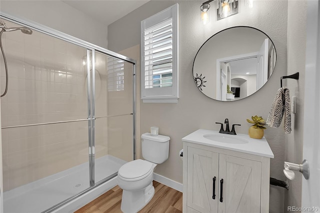 bathroom with toilet, hardwood / wood-style floors, vanity, and walk in shower