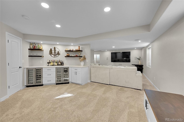 bar featuring white cabinetry, light carpet, and beverage cooler