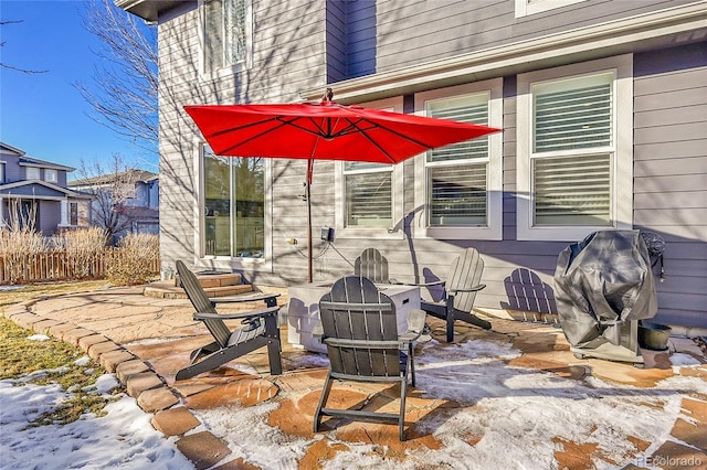 snow covered patio with a grill