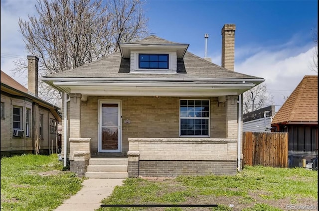 bungalow-style home featuring a chimney, fence, cooling unit, and brick siding