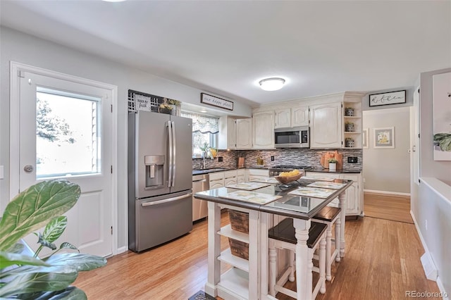 8262 Otis Ct, Arvada, CO 80003 - kitchen with stainless steel appliances, open shelves, backsplash, dark countertops, and light wood-type flooring