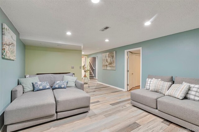 8262 Otis Ct, Arvada, CO 80003 - living room with light wood-type flooring, a textured ceiling, recessed lighting, and stairs