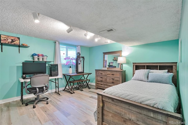 8262 Otis Ct, Arvada, CO 80003 - bedroom with a textured ceiling, wood finished floors, a desk, and rail lighting