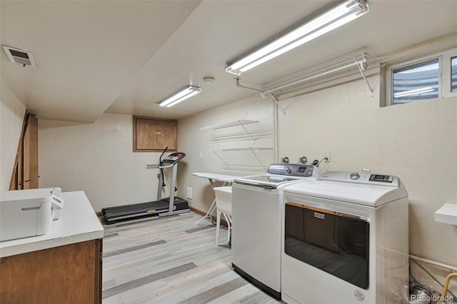 8262 Otis Ct, Arvada, CO 80003 - laundry room featuring washer and clothes dryer, cabinet space, and light wood-style floors