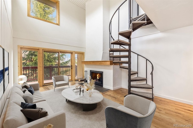 21 Buffalo Dr Unit 28, Silverthorne, CO 80498 - living room with stairway, a high ceiling, a lit fireplace, wood finished floors, and baseboards