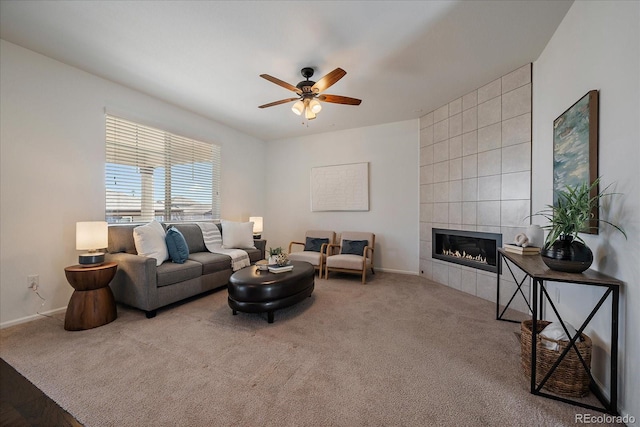 carpeted living area with a ceiling fan, baseboards, and a tiled fireplace