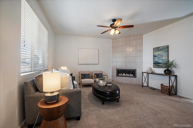 carpeted living area featuring a fireplace and ceiling fan