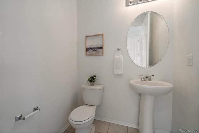 bathroom with toilet, baseboards, a sink, and tile patterned floors