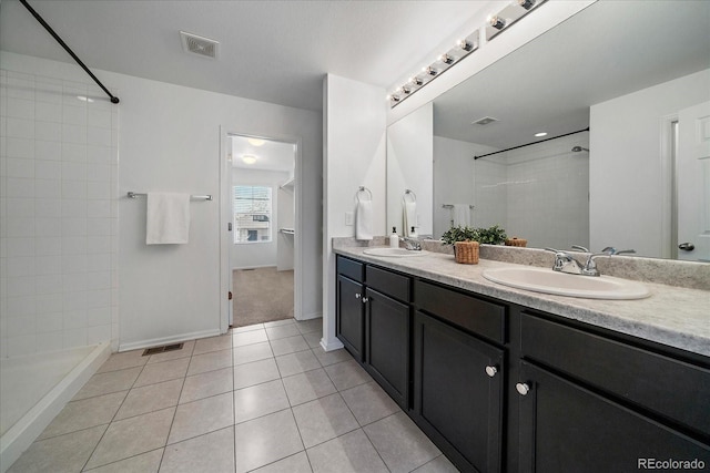 full bathroom featuring a sink, a tile shower, visible vents, and tile patterned floors