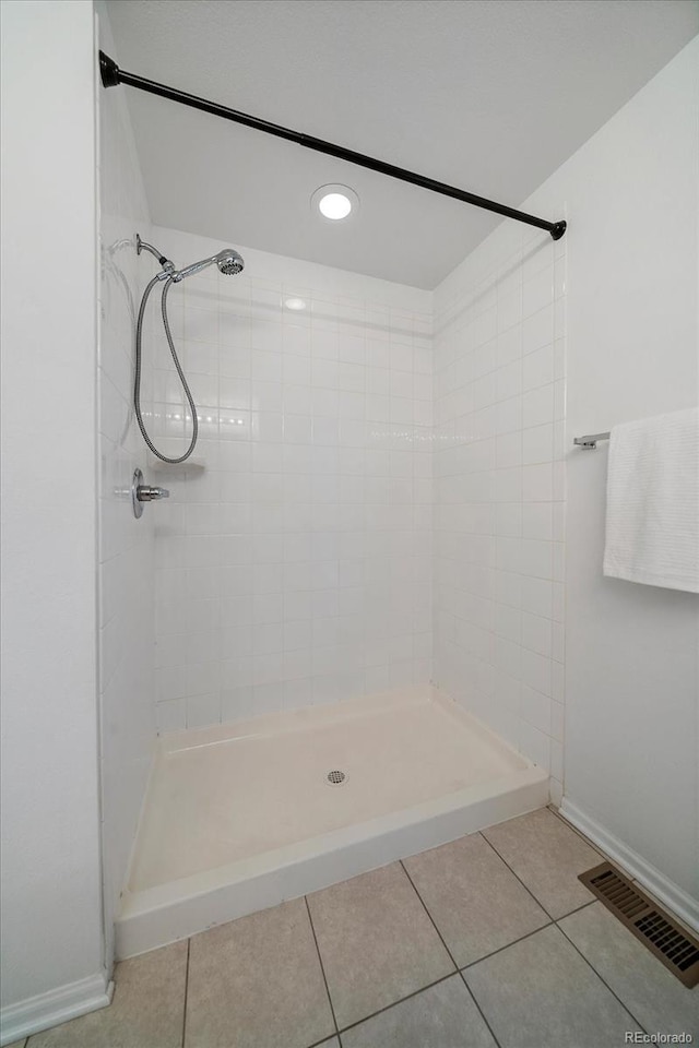 bathroom with baseboards, a shower stall, visible vents, and tile patterned floors