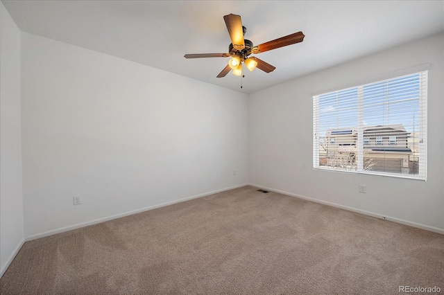 empty room with a ceiling fan, light carpet, visible vents, and baseboards