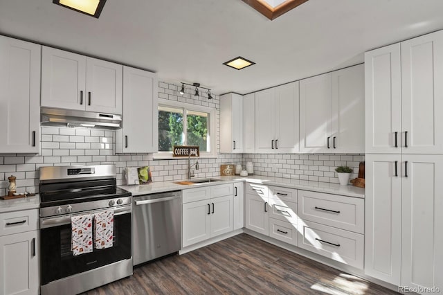 295 E Amherst Ave, Englewood, CO 80113 - kitchen with stainless steel appliances, under cabinet range hood, a sink, and white cabinetry