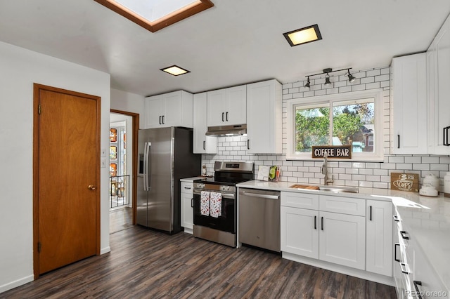295 E Amherst Ave, Englewood, CO 80113 - kitchen featuring stainless steel appliances, a sink, under cabinet range hood, light countertops, and dark wood-style flooring