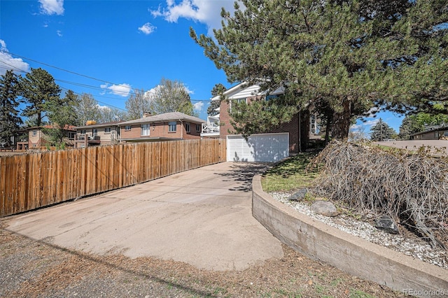 295 E Amherst Ave, Englewood, CO 80113 - view of side of property with concrete driveway, brick siding, fence, and a garage
