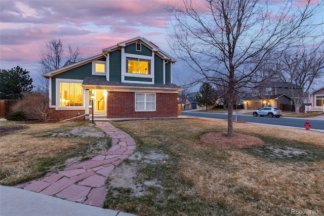 view of front of house featuring a yard and brick siding