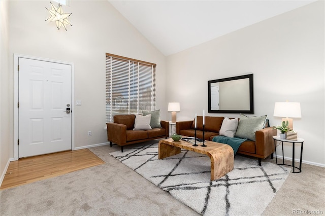 carpeted living area featuring high vaulted ceiling and baseboards