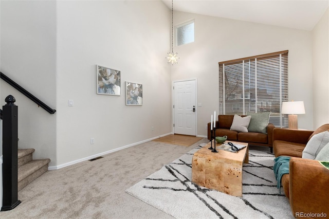 living room with stairs, carpet flooring, visible vents, and baseboards