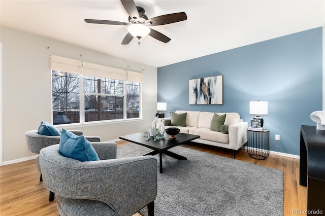 living room with wood finished floors, baseboards, and ceiling fan