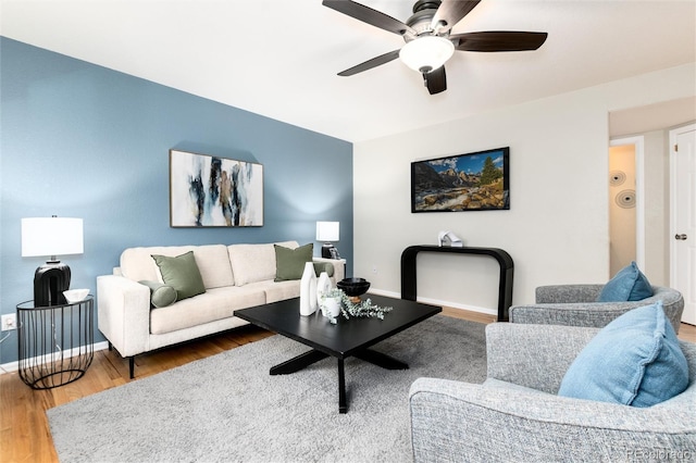 living room featuring a ceiling fan, wood finished floors, and baseboards