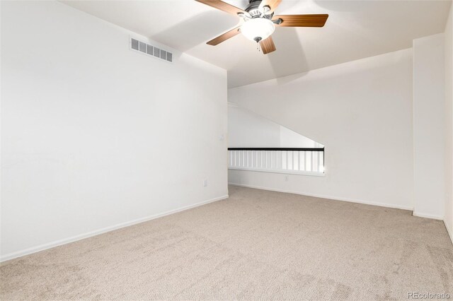 carpeted spare room with a ceiling fan, baseboards, and visible vents