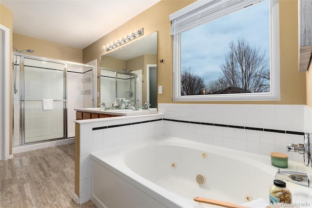 full bathroom with a jetted tub, wood finished floors, and a stall shower