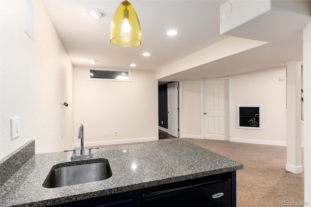 kitchen featuring dark stone countertops, carpet, a sink, black dishwasher, and dark cabinets