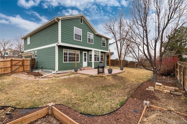 back of house featuring entry steps, a yard, a patio area, and a fenced backyard