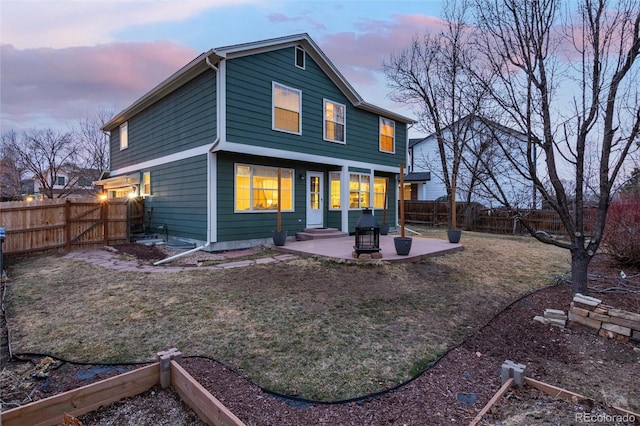 rear view of property featuring a fenced backyard and a patio area