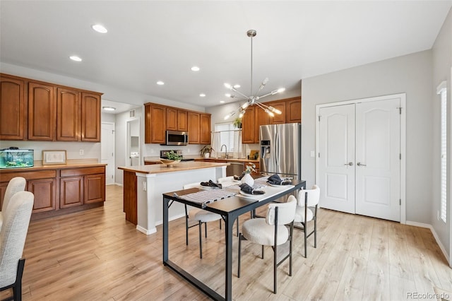 6723 Silverwind Cir, Colorado Springs, CO 80923 - kitchen featuring stainless steel appliances, brown cabinetry, recessed lighting, light countertops, and light wood-style floors