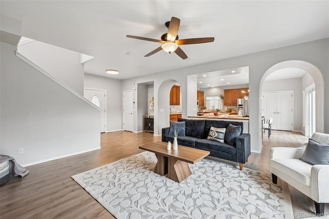 6723 Silverwind Cir, Colorado Springs, CO 80923 - living room with arched walkways, light wood-style floors, ceiling fan, and recessed lighting