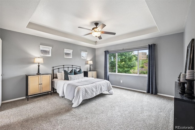 6723 Silverwind Cir, Colorado Springs, CO 80923 - carpeted bedroom with a raised ceiling and a ceiling fan