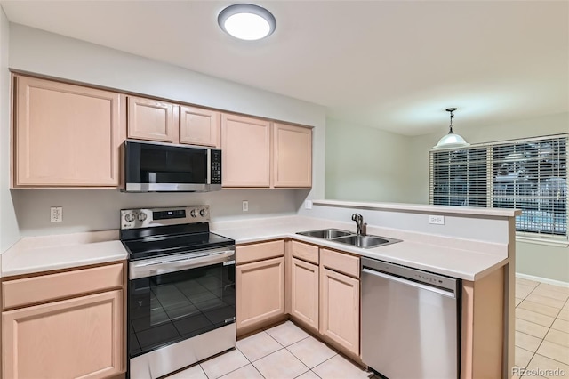 1121 W 112th Ave Unit C, Denver, CO 80234 - kitchen featuring stainless steel appliances, light brown cabinetry, a peninsula, light tile patterned floors, and light countertops