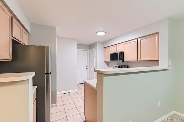 1121 W 112th Ave Unit C, Denver, CO 80234 - kitchen with stainless steel appliances, light countertops, a peninsula, and light tile patterned floors