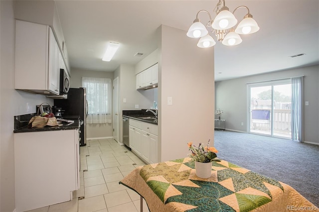 kitchen featuring sink, a notable chandelier, appliances with stainless steel finishes, white cabinetry, and light colored carpet