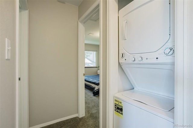 clothes washing area featuring dark colored carpet and stacked washer and dryer