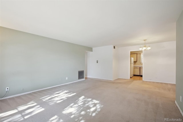 unfurnished living room featuring light carpet and a chandelier