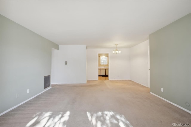 unfurnished living room with light colored carpet and a chandelier