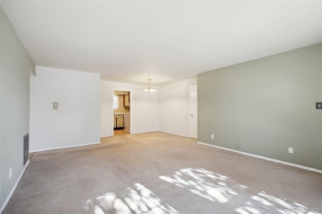 unfurnished room featuring light carpet and a chandelier