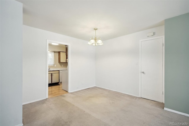 unfurnished room with light carpet and a chandelier