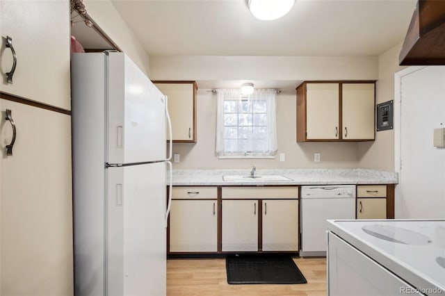 kitchen with white appliances, light wood-type flooring, cream cabinets, and sink